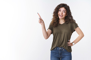 Cheerful talkative charming armenian young girl with curly hair standing upbeat excited pointing...