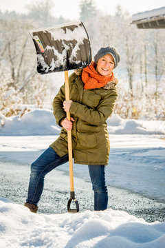 Frau beim Schneeschaufeln