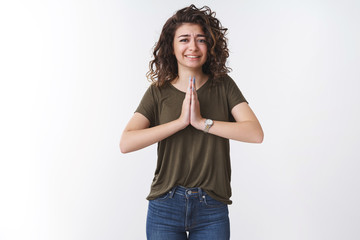 Nervous cute begging young girl press palms together pray say please cringing hopefully supplicating your mercy apologizing anxiously, standing worried white background wearing olive t-shirt