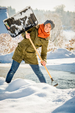Frau beim Schneeschaufeln
