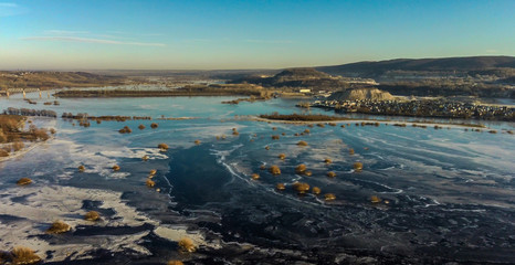 Aerial drone view above forzen river with small bush islands and Zhighuli hills in Samara region, Russia