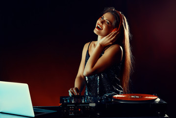 Female dj playing music in nightclub