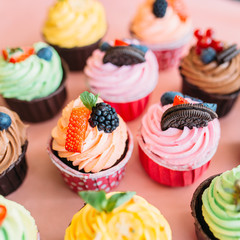 Assorted cupcakes on pink background