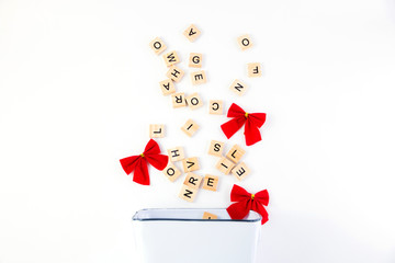 Text, message, letter scattered in white rectangular bucket with red bows isolated on white background