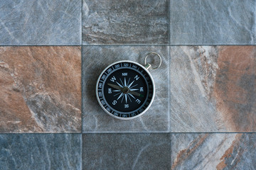 Old compass on stone floor background