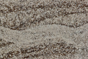 Mocha flavored powdered creamer from a side view through a clear container with macro lens. Looks like layers of sand.