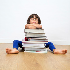 overwhelmed sleepy child with bookworm eyeglasses sleeping on stack of books