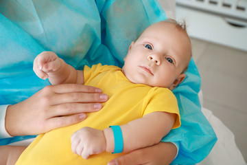 Young woman with newborn baby in maternity hospital, closeup