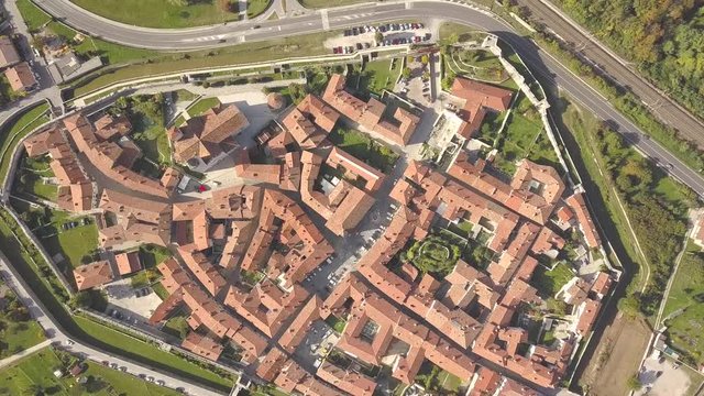 Top down aerial view of a small historic town Venzone in Northern Italy with red tiled roofs of old buildings.