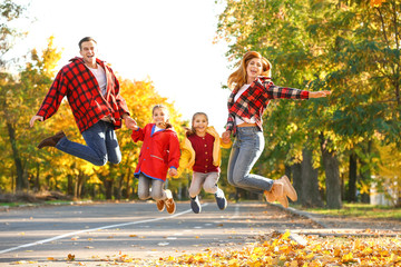 Happy family having fun in autumn park