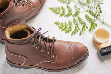 ฺBrown leather shoes with vintage camera on a wooden floor.Brown vintage leather boots aligned selective focus.Men leather shoes 