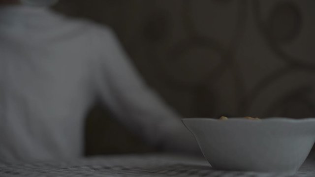 defocused girl wearing white clothes with black wrist watch drinks tea from nice cup and eats bagels close view