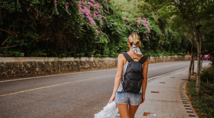 Traveler blonde backpacker woman  walking on path in the tropical forest, Travel adventure nature in China, Tourist beautiful destination Asia, Summer holiday vacation trip, Copy space for banner