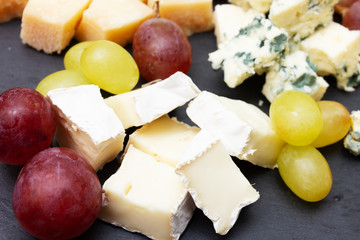 Assorted cheeses on a black plate