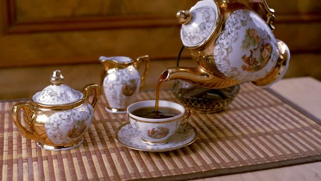 The coffee service looks beautiful.Coffee is poured into a Cup Porcelain coffee set with a Cup, sugar bowl, kettle. Retro.