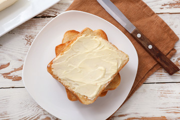 Tasty toasted bread with butter on table