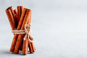 Cinnamon sticks, tied with jute rope on gray stone background