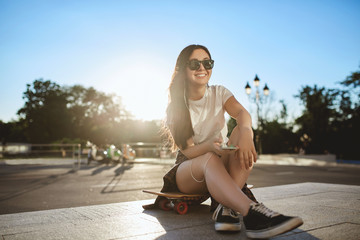 Urban teenage lifestyle, sport and leisure concept. Cheerful cool brunette skater girl in skate...
