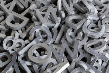 pile of white metal alphabet characters cutted by waterjet machine