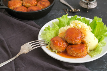Meatballs in sweet and sour tomato sauce with mashed potatoes.