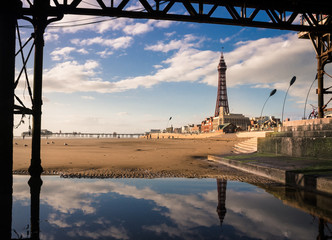 Blackpool Tower and iconic promenade buildings seen from beneath the Central Pier on a sunny evening