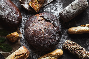Different types of bread on black background