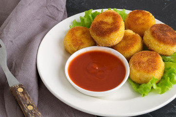 breaded fried potato balls with tomato sauce