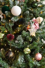 Closeup of garland, balls and tiny toys hanging on Christmass tree