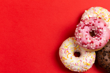 Ciambelle glassate su sfondo rosso