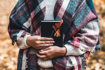 Fototapeta premium Woman holds a book in her hands, close-up, autumn