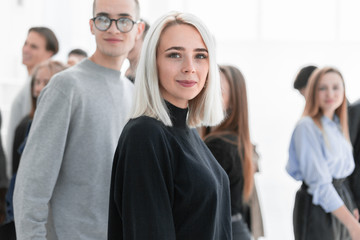 casual young woman standing among diverse young people.