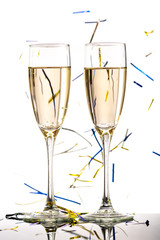 Two glasses with white wine champagne with falling tinsel on the background