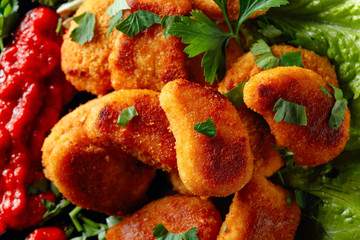  Fried chicken nuggets with ketchup, sprinkled with chopped parsley.