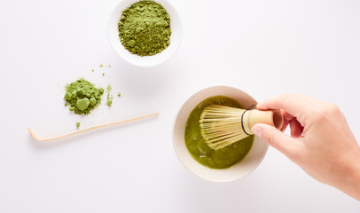  Matcha green tea powder view from above, traditional matcha tea preparing , white background. Flat lay 