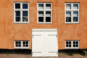 Fototapeta na wymiar Orange Typically Danish House with Windows and Cellardoor