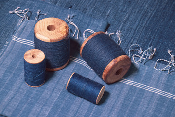 Indigo dyed yarn in reel and indigo dyed woven fabric background