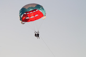 paragliding in the sky over the blue sea