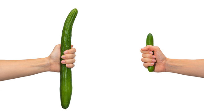 Man penis size concept, hands holding big and small cucumbers, isolated on white background.