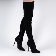sexy textile female boots above knees on model legs shooting in studio on a white background