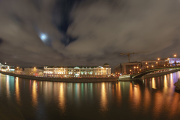 Fototapeta premium Moscow cityscape at autumn night. Bridge, reflections of city lighting on the water surface. Moskva river embankment. Long exposure photography