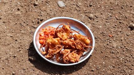 Deep fried kanda bhajiya served in a bowl. Spicy indian food.