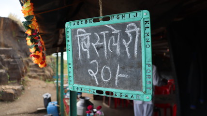 Pune, Maharastra/India- November 18 2019: Chalk and black board slate. Bisleri water bottle for sale in a shop.