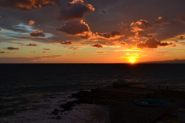 Fototapeta na wymiar Cielo rosso fuoco al tramonto sul mare
