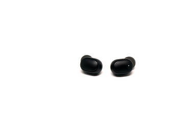 Black In ear headphone - bluetooth wireless isolated white background - music technology trends 2020 