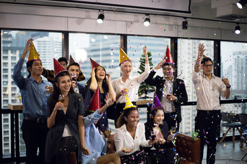 Smiling young Business people on New Year Party in Office and drinking champagne for New Year celebration.