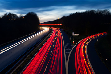 Autobahn Deutschland Abenddämmerung Lichtspruen Anschlussstelle Ausfahrt Auffahrt Brücke Kurve...