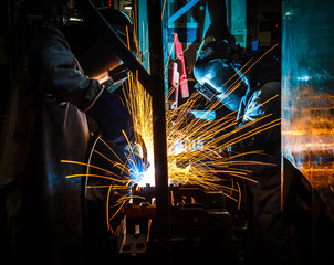 worker with protective mask welding metal