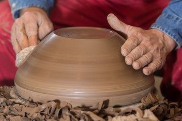 Professional male potter making ceramics on potters wheel in workshop, studio. Close up shot of potters hands. Handmade, art and handicraft concept