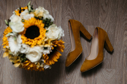 photo of wedding bouquet and shoes taken from above on the floor. 