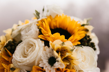 close up photo of wedding bouquet of sunflowers and roses. 